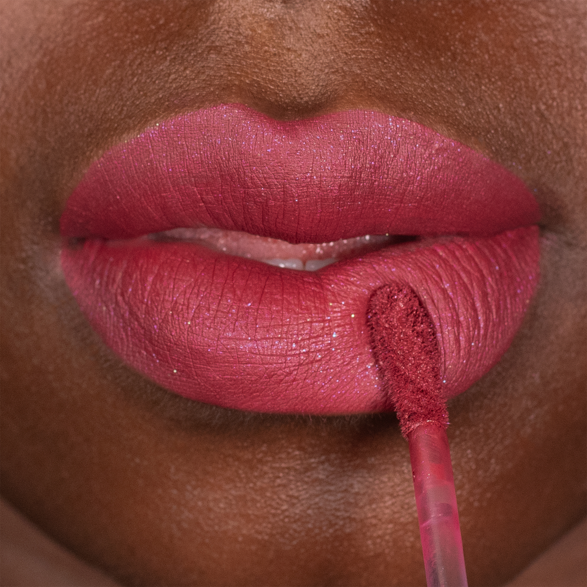 Nahaufnahme einer Person, die den „Over The Garden Wall Velvet Liquid Lipstick“ von Lethal Cosmetics mit einem Applikator auf ihre Lippen aufträgt.