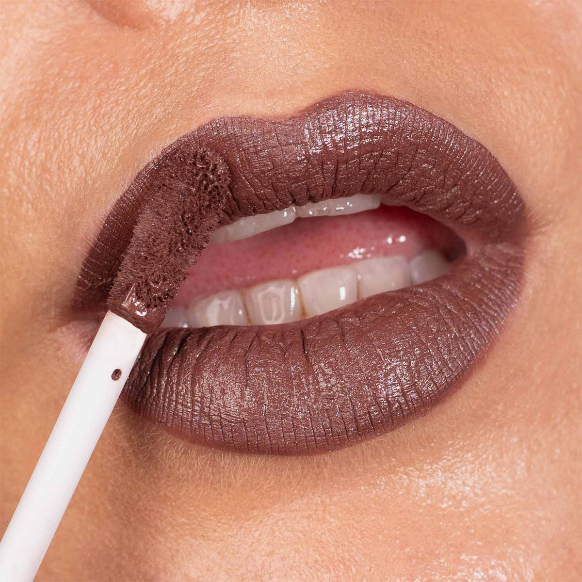 Nahaufnahme einer Person, die den „Over The Garden Wall Rock Fact Velvet Liquid Lipstick“ von Lethal Cosmetics mit einem weißen Applikator aufträgt.