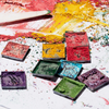 Die Palette 1993 von LH Cosmetics besteht aus farbenfrohen Pastellpudern und -quadraten, die auf weißem Papier mit einem weißen Stift verstreut sind.