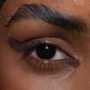 Nahaufnahme eines braunen Auges mit geflügeltem Liner und geformten Augenbrauen mit The Single von LH Cosmetics.