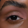 Nahaufnahme eines braunen Auges mit natürlichem Make-up und definierten Brauen, mit The Single von LH Cosmetics.