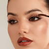 Eine Frau trägt die Femuline™ Brownie Mascara von Mesauda Beauty auf ihre Wimpern auf, hier in einer Nahaufnahme ihres Gesichts.
