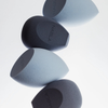Vier NABLA Cosmetics Blended-up Pro Tapered Sponges in Blau und Grau, diagonal angeordnet auf weißem Hintergrund.