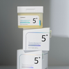 Numbuzin No.5 Vitamin-Niacinamide Concentrated Pads im transparenten Tiegel mit weißem Deckel, daneben gestapelte Produktboxen mit schlichtem Design.