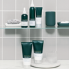 Philip Kingsley Density Thickening Shampoo auf Glasregalen in einem modernen Badezimmer mit grauen Fliesen und minimalistischer Einrichtung.