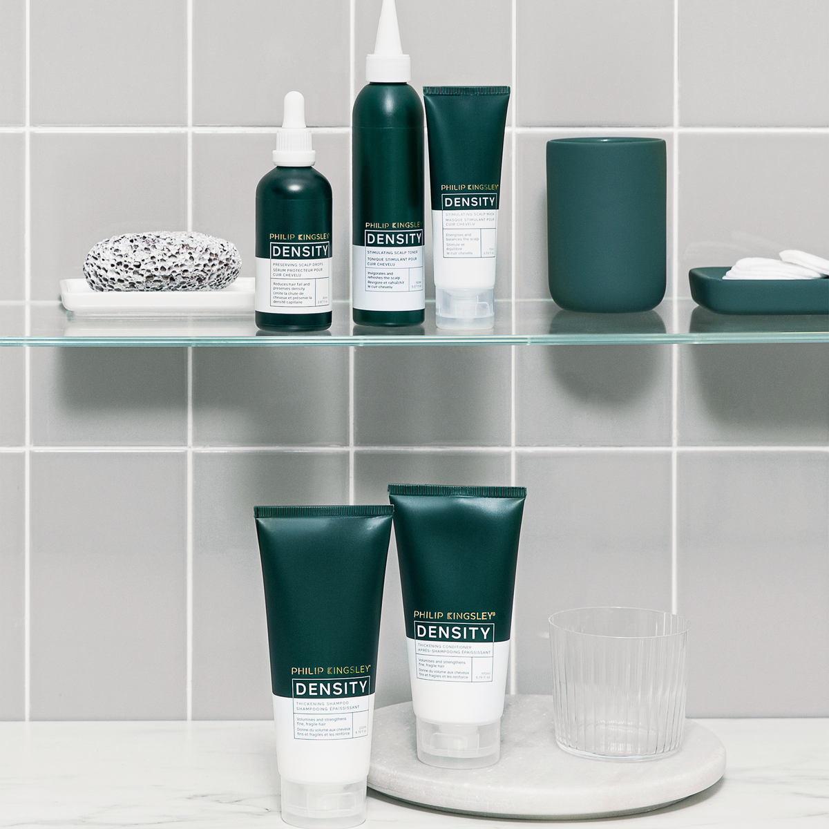 Philip Kingsley Density Thickening Shampoo auf Glasregalen in einem modernen Badezimmer mit grauen Fliesen und minimalistischer Einrichtung.