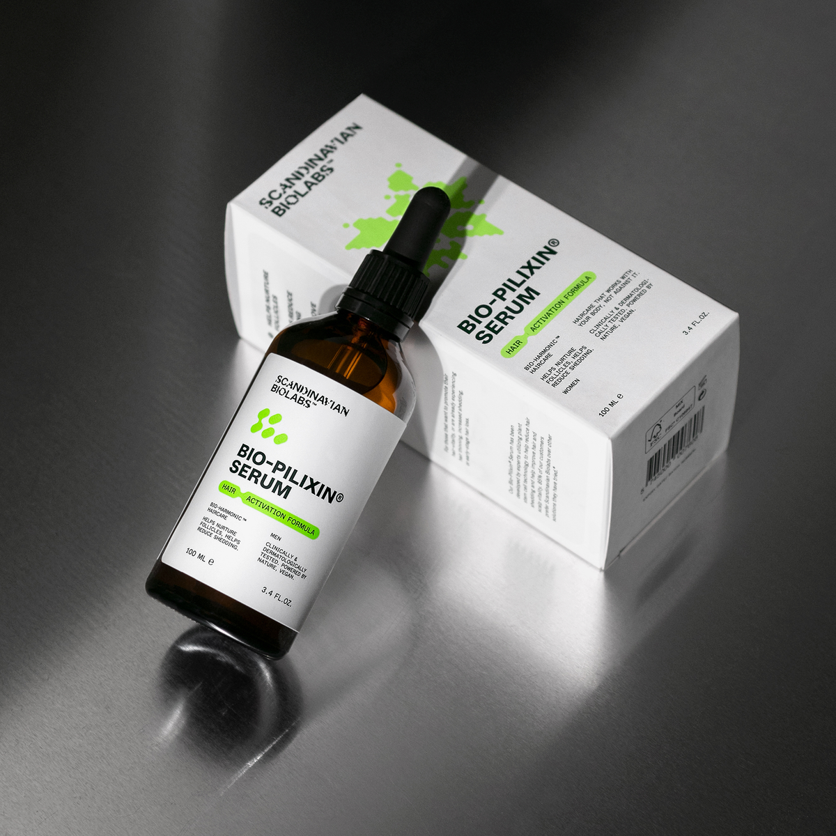 Ein Fläschchen Bio-Pilixin® Serum von Scandinavian Biolabs mit Tropfer steht neben der weißen Schachtel auf einer Metalloberfläche.