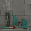 Ein mintgrüner Foundation-Pinsel von SWEED liegt auf einem Waschbecken vor einem Hintergrund aus weißen Metrofliesen, daneben liegen passende Make-up-Produkte.