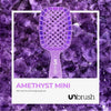 Große Version der UNbrush Glitter Duo Wet and Dry Detangling Brush von UNbrush auf einem Amethystkristall-Hintergrund abgebildet.