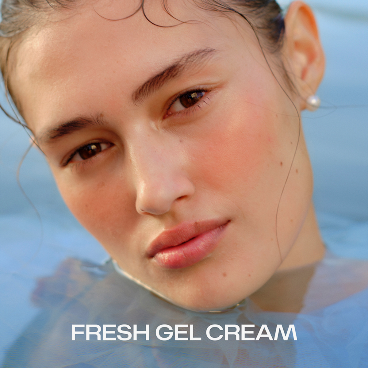 Frau mit taufrischer Haut im Wasser, Nahaufnahme, mit Perlenohrring. Text: LUMENE Nordic Hydra Hydrating Eye Gel Cream.