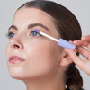 Eine Frau trägt das BLONDESISTER 2 IN 1 EYES FIRST LASH&BROW SERUM auf ihre Wimpern auf und schaut dabei leicht nach oben.