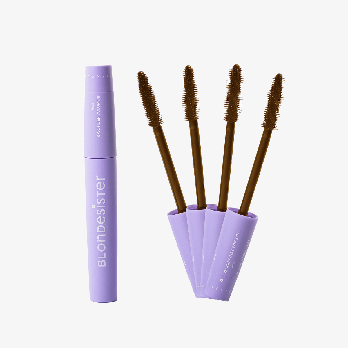 Eine lavendelfarbene BLONDESISTER 4-IN-1-CLICK-&-TURN-MASCARA-Tube mit vier braunen Bürstchen daneben auf weißem Hintergrund.