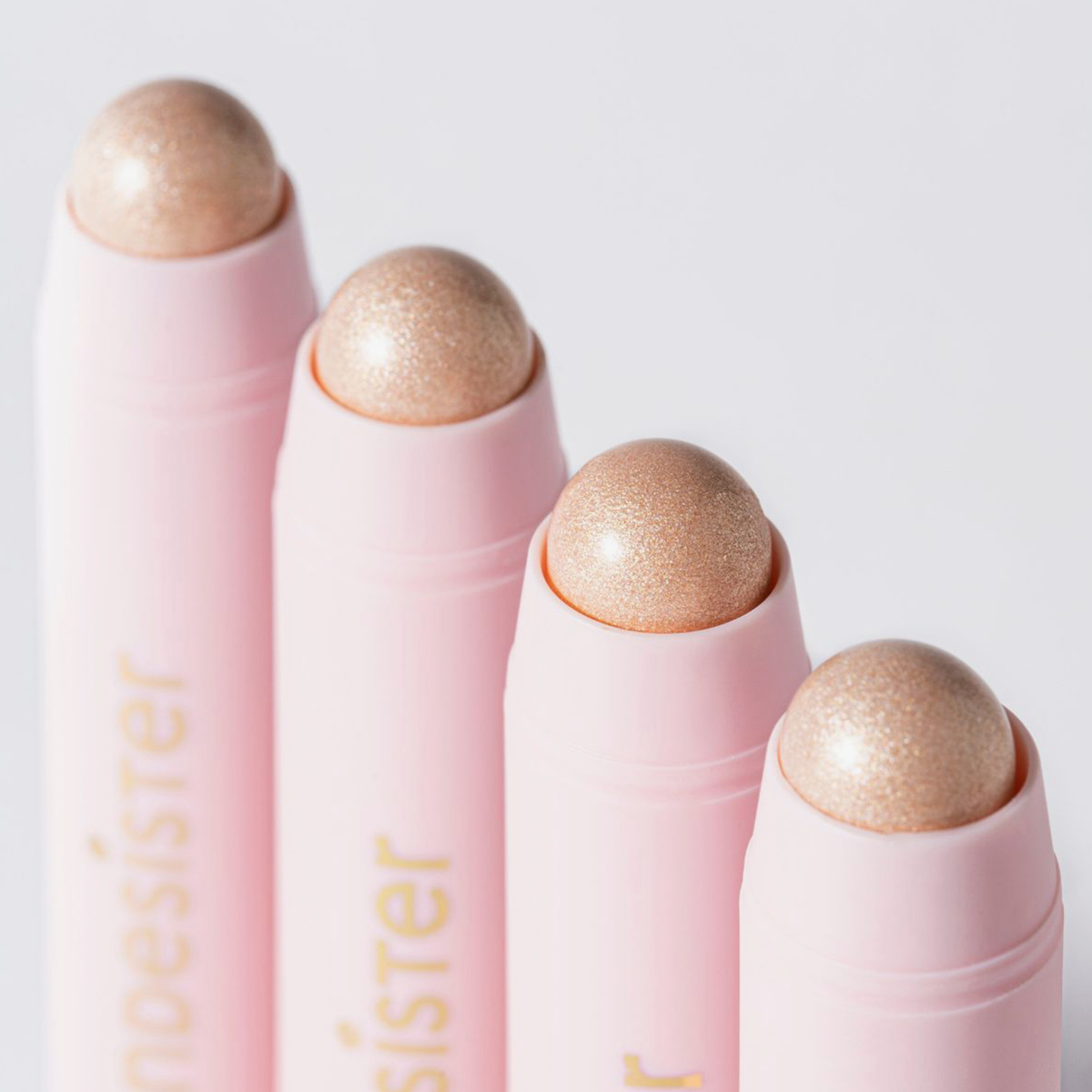 Vier „BLONDESISTER READY TO GLOW HIGHLIGHTER CRYSTAL MOOD 01“-Stifte sind diagonal auf einem weißen Hintergrund angeordnet.