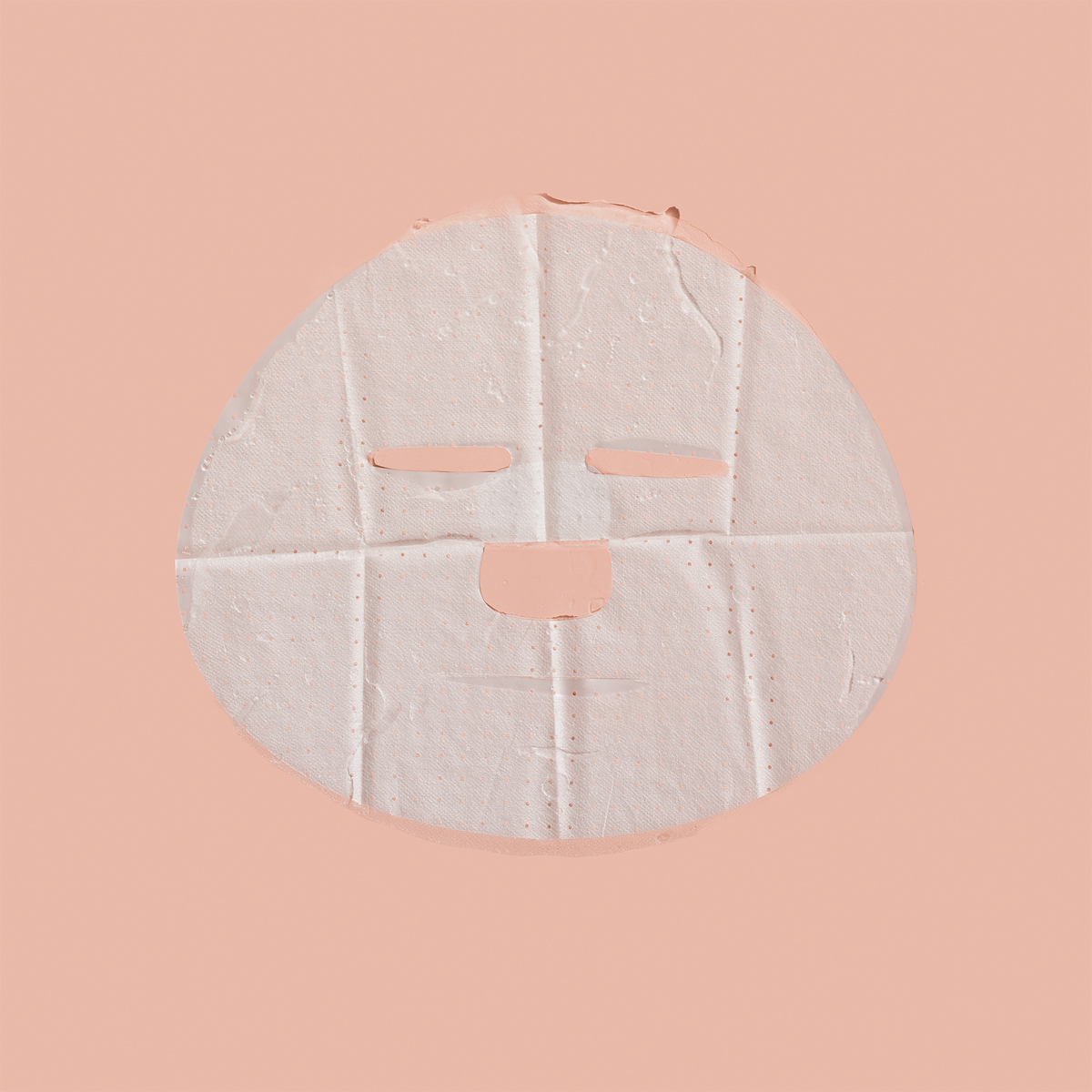 Eine runde, weiße Breakout+Aid-Salicylsäure-Klärungsmaske mit Aussparungen für Augen, Nase und Mund.
