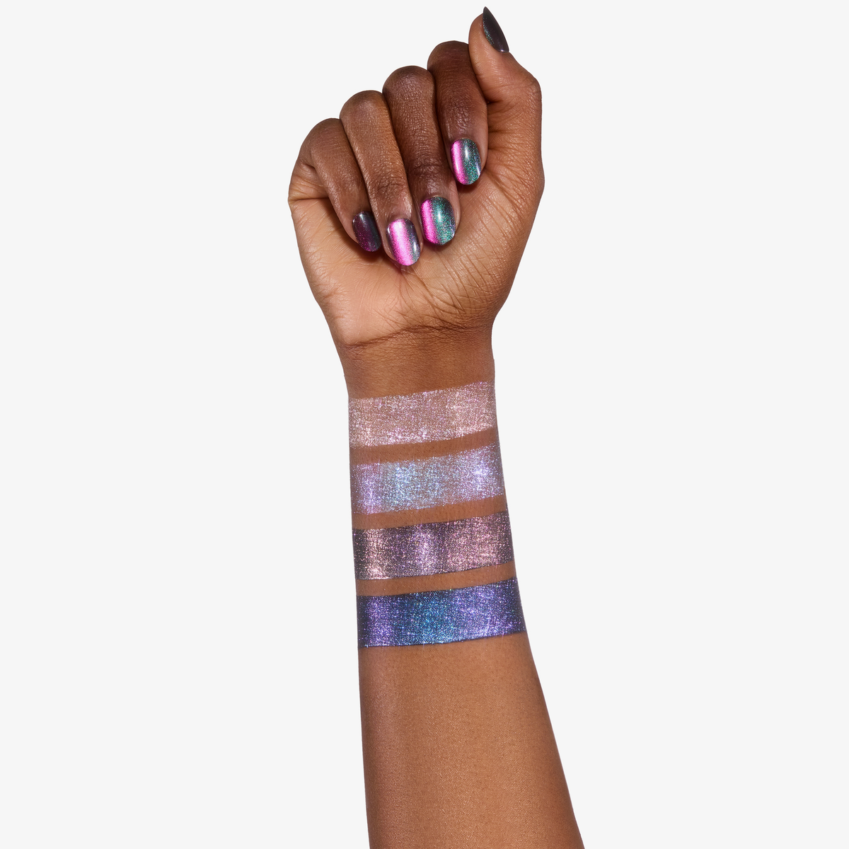 Eine Hand mit schillernden Nägeln zeigt vier Colorfix Stix Infinity-Farbmuster von Danessa Myricks Beauty auf dem Unterarm.