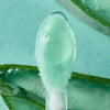 Ein klares Gel von Essence jelly GRIP EYESHADOW PRIMER befindet sich auf dem Applikator mit Aloe-Vera-Blättern im Hintergrund.