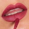 Nahaufnahme der Lippen mit dem flüssigen Lippenstift „Over The Garden Wall – Poetry & Clarinet Velvet“ von Lethal Cosmetics, der mit einem Applikator aufgetragen wurde.