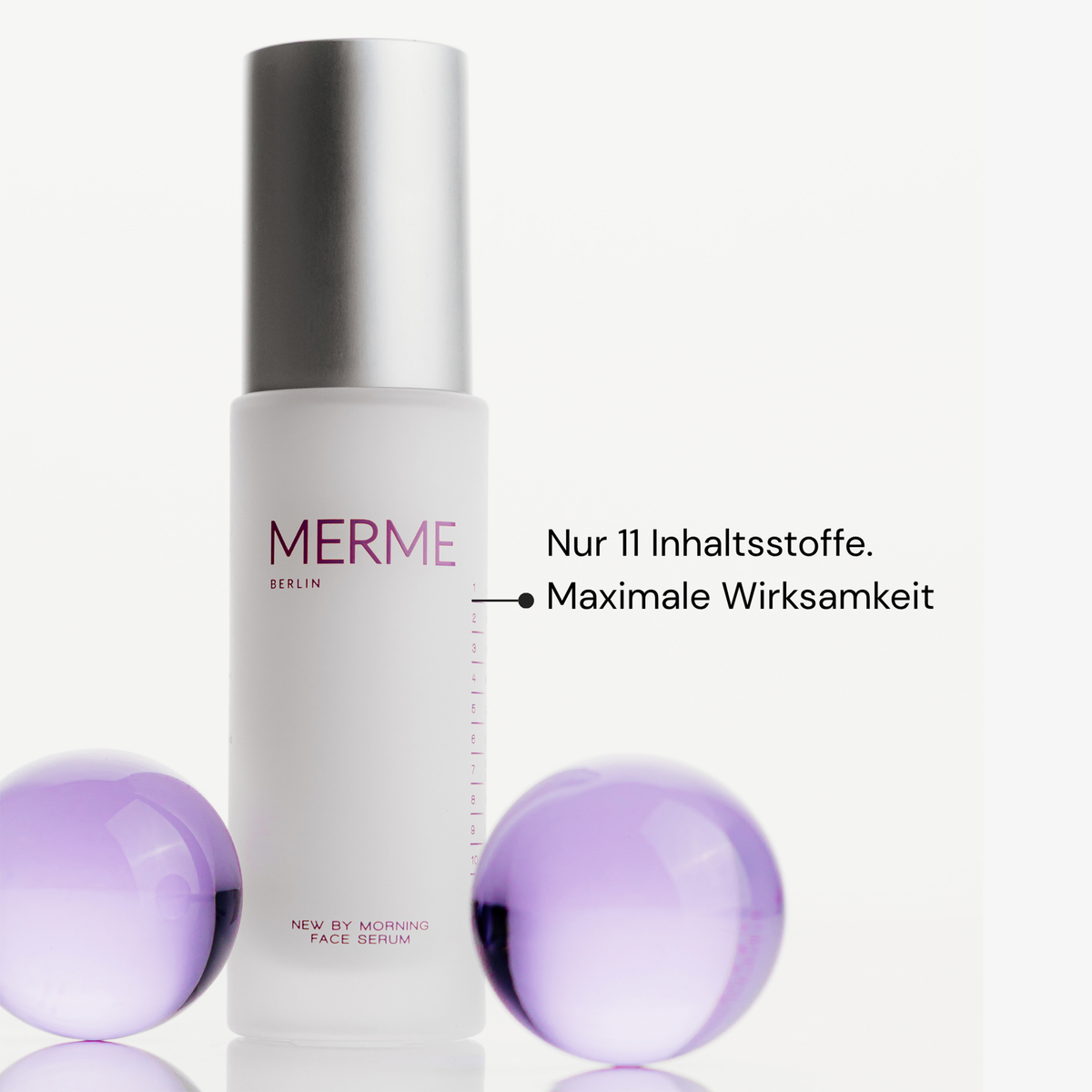 MERME New by Morning Retinal Face Serum in einem minimalistischen Flakon mit zwei lila Kugeln und deutschem Text zu Inhaltsstoffen und Wirksamkeit.
