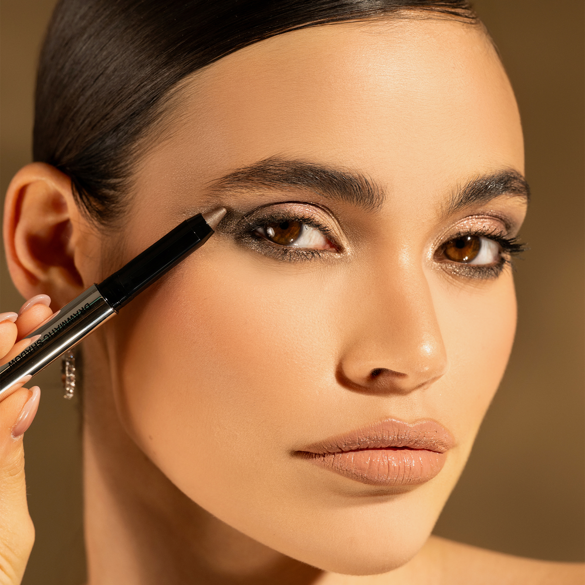 Frau mit glattem, zurückgebundenem Haar trägt schimmernden Lidschatten und betont ihr Auge mit dem Mesauda Drawmatic Shadow Stick.