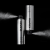 Zwei silberne OLAPLEX Shape Set Hairspray-Sprühdosen, aus denen Haarspray vor einem schwarzen Hintergrund versprüht wird.