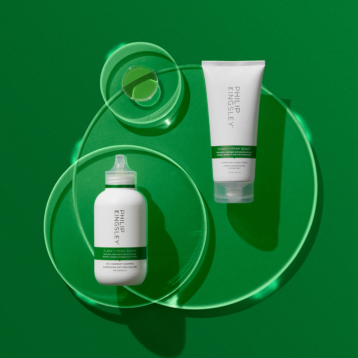 Philip Kingsley Shampoo gegen schuppige, juckende Kopfhaut vor grünem Hintergrund mit gläsernen Kreisen und einem Klecks Gel.