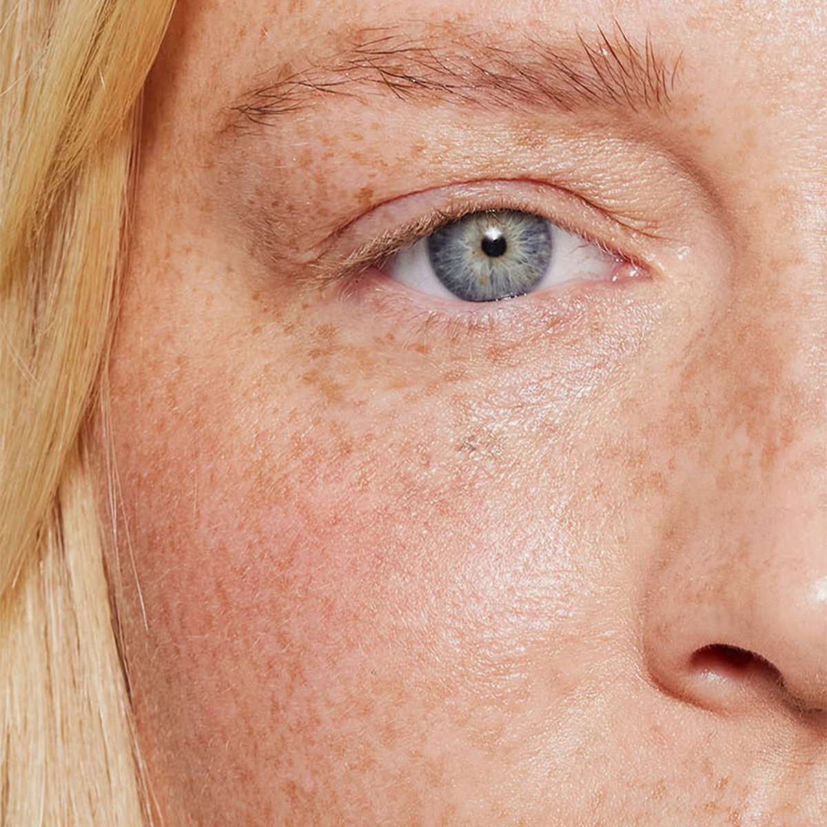 Nahaufnahme eines blauen Auges und einer Augenbraue, die mit dem Brow Booster von XLASH betont wurden.