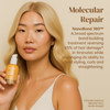 Eine Frau mit langen blonden Haaren hält vor einem beigen Hintergrund eine Flasche „Abyssian Dream Bonds Bio Emulsion“ in der Hand; die Produktdetails sind zu sehen.
