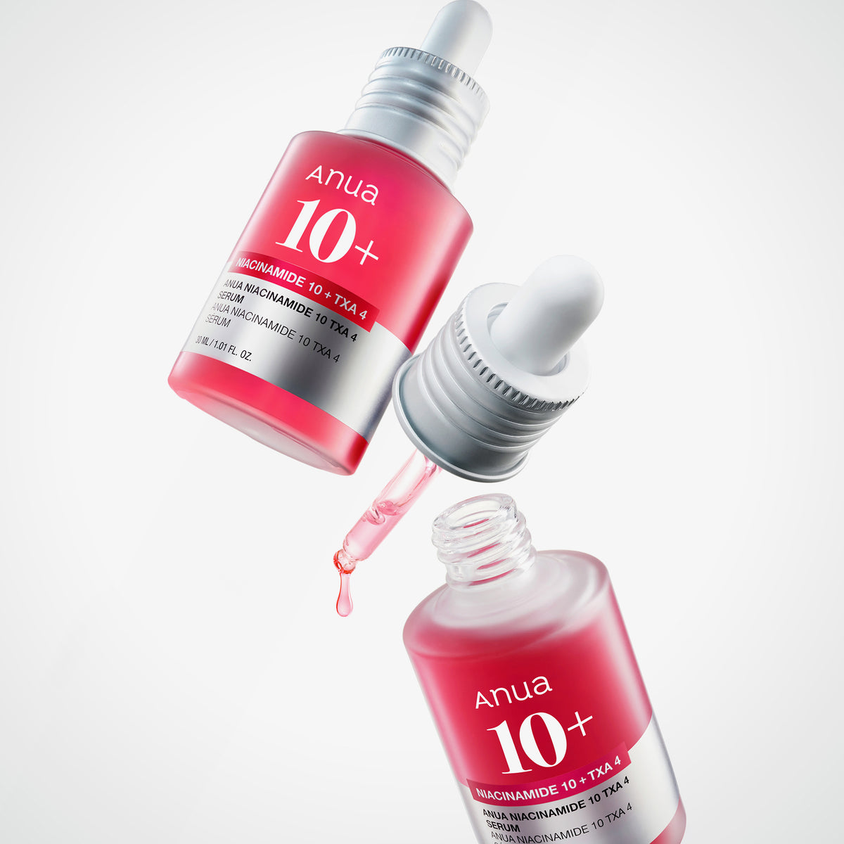Zwei rosa Flaschen mit dem Dark Spot Correcting Serum, eine davon geöffnet und mit einer Pipette, die Flüssigkeit abgibt.