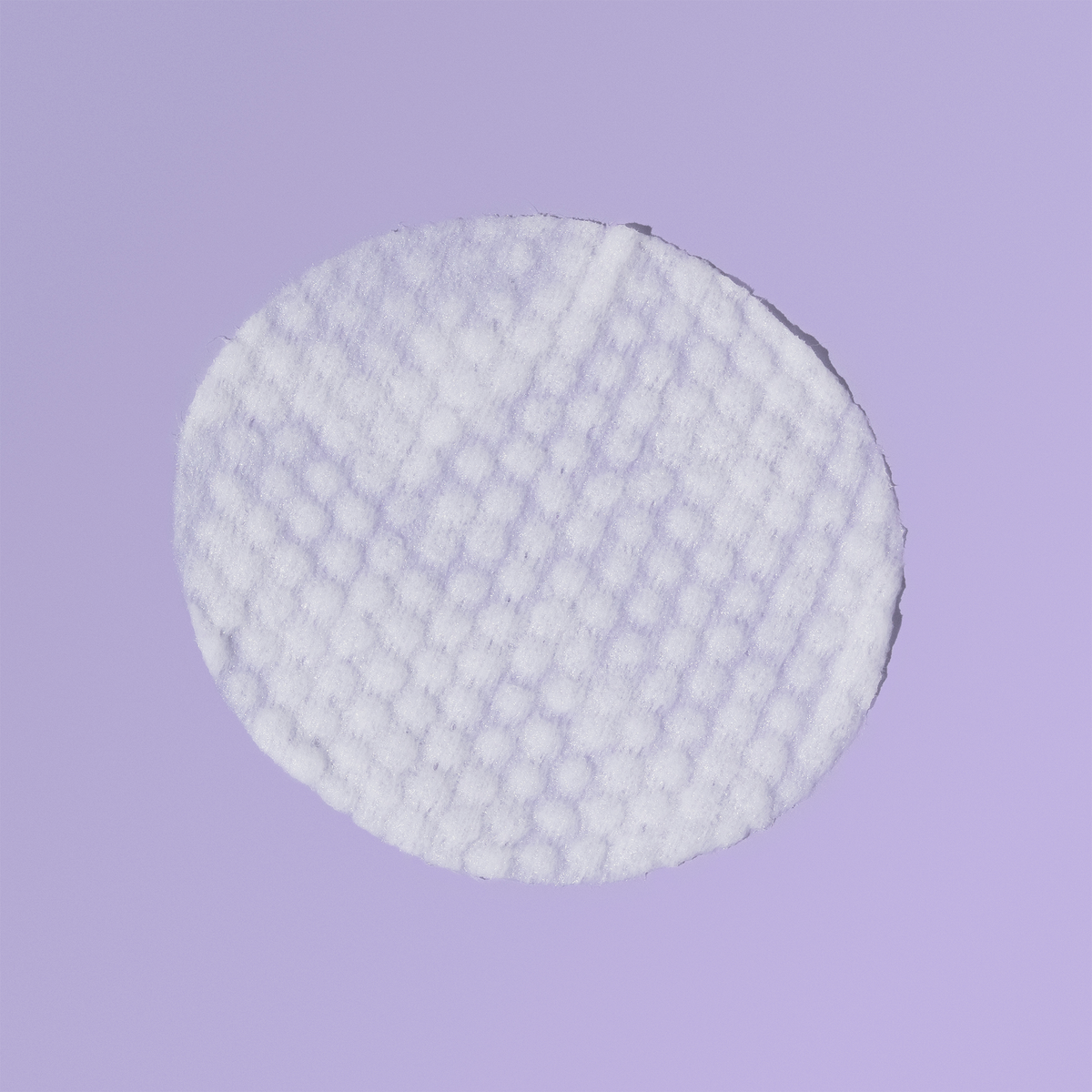 Eine einzelne runde, strukturierte Blueberry & Açaí-Mini-Maske + Toner-Pad auf hellviolettem Hintergrund.