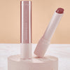 Ein offener Catrice Cosmetics Diamond Glaze Gloss Stick Lippenstift in Pink wird auf einem runden, strukturierten Ständer präsentiert.