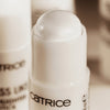 Eine Nahaufnahme des geöffneten Glass Like Highlighter Stick 010 mit einer perlweiß schimmernden Spitze in einer schlichten weißen Tube.