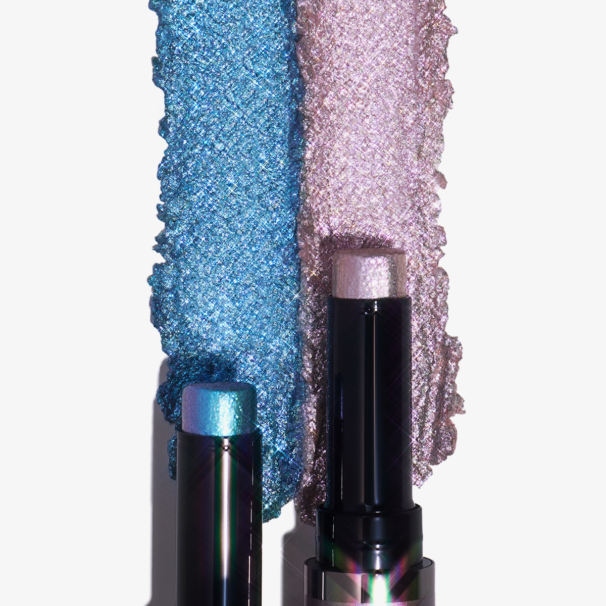 Zwei Colorfix Stix Infinity-Lippenstifte von Danessa Myricks Beauty in Blau und Rosa, gezeigt mit passenden Mustern auf Weiß.