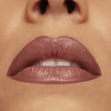 Nahaufnahme der Lippen einer Frau, die das CULT CREAMY LIP KIT von Mesauda Beauty in einem matten Mauve-Ton trägt, leicht gescheitelt, um weiße Zähne und glatte Haut zu zeigen.
