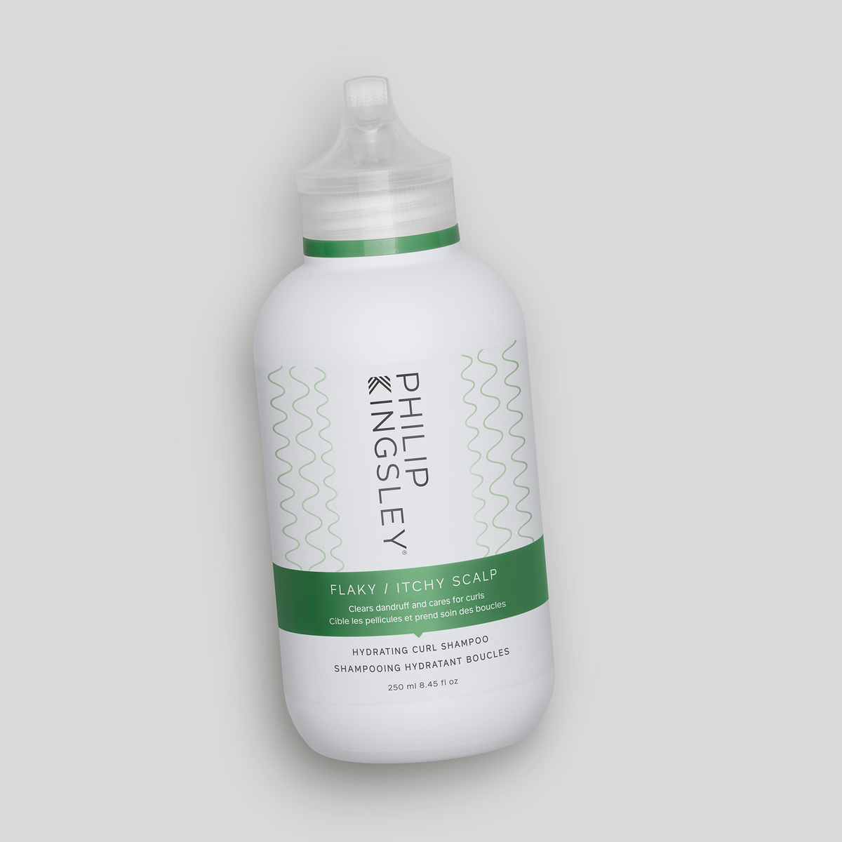 Weiße Flasche „Philip Kingsley Flaky/Itchy Scalp Hydrating Curl Anti-Dandruff Shampoo“ mit grünem Etikett auf grauem Hintergrund.