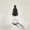 Kleine Flasche mit Gesichtsserum aus dem Winter Collagen Bank Set mit Tropfverschluss und einem weißen Etikett mit der Aufschrift Lunar Serum Concentrate.