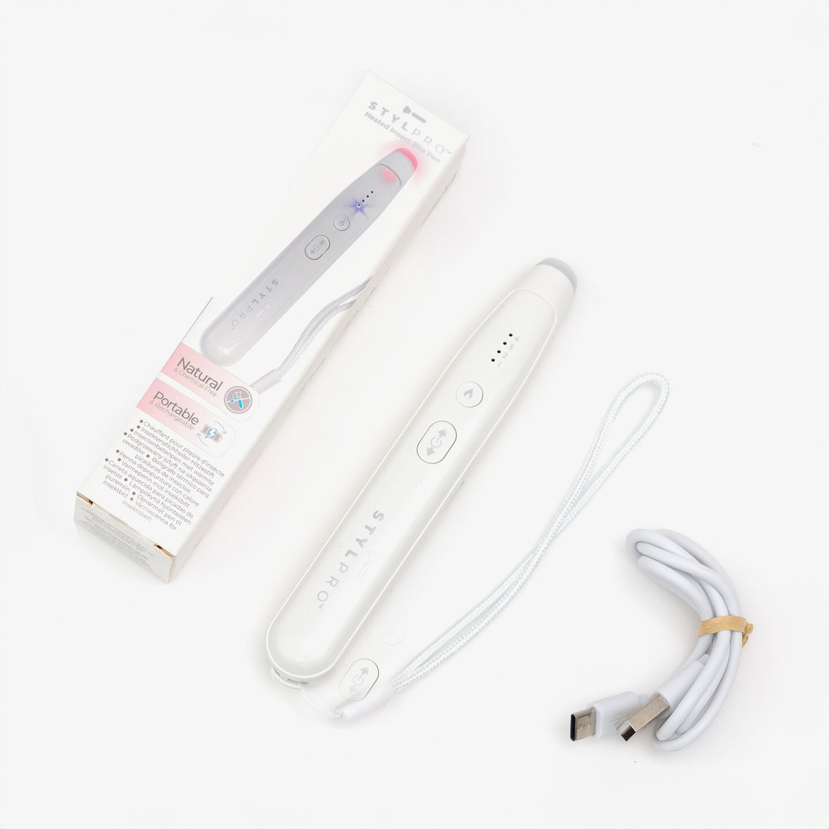 Der STYLPRO Bite Pen, ein weißes elektronisches Schönheitsgerät, wird mit seiner Verpackung und dem USB-Ladekabel auf weißem Hintergrund gezeigt.