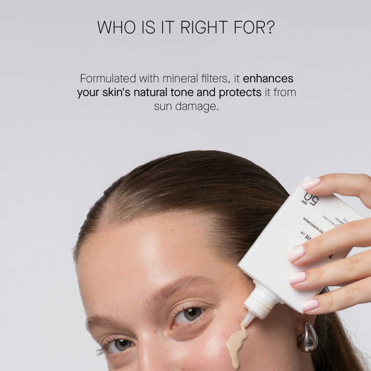 Eine Person trägt „Transparent Lab Mineral Tinted Sunscreen“ unter den Augen auf; darüber sind die mineralischen Filter und der Sonnenschutztext zu sehen.