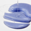 Ein klares Serum wird auf einen Stapel blauer, halbmondförmiger XLASH Longevity Multi-Zone-Gele gegossen.