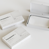 Drei minimalistische weiße Kopfkissenbezugsboxen, zwei geschlossene und eine offene, mit dem Branding Transparent Lab" auf weißer Oberfläche.