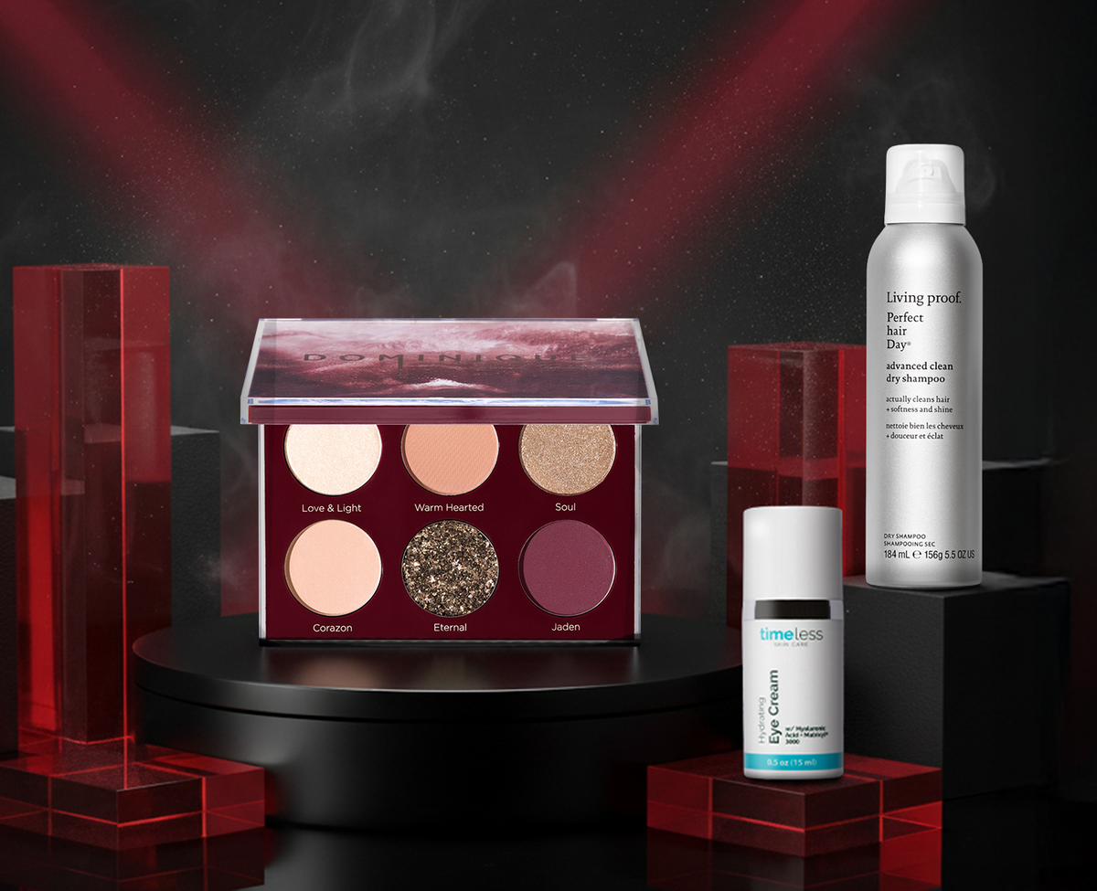 Drei Beautyprodukte auf schwarzen Podesten vor dunklem Hintergrund mit Lichteffekten: Dominique Cosmetics Unconditional Palette, Timeless Skin Care Hydrating Eye Cream und Living Proof. Perfect Hair Day Advanced Clean Dry Shampoo.