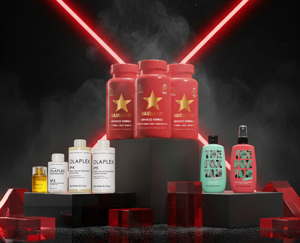 Drei Beauty Bundle auf schwarzen Podesten vor dunklem Hintergrund mit roten Lichtlinien: HAIRtamin Advanced Formula 3 Month Bundle, OLAPLEX Love Your Hair Bundle und The Best of The Fox Tan Bundle.