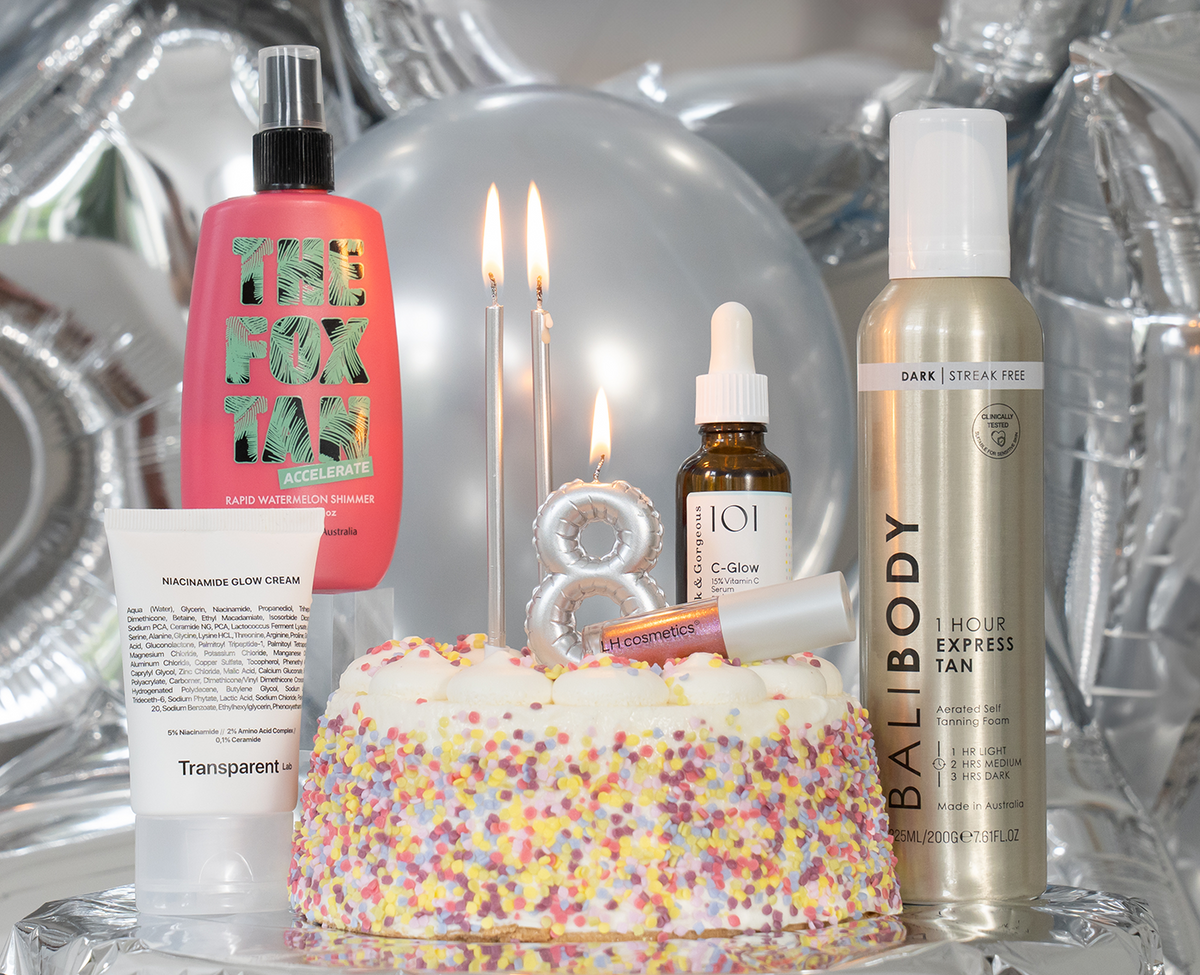 Beautyprodukte und Make-up vor silbernen Luftballons; in der Mitte eine bunte Torte mit Kerzen in Form einer 8 – zum 8. Geburtstag von Purish.com