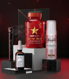 Vier Beauty-Produkte auf schwarzen Podesten vor dunklem Hintergrund mit roten Lichtakzenten: Geek & Gorgeous C-Glow Serum, Hairtamin Gummy Stars, NABLA Vicious Mascara und Loving Tan Bronzing Mousse.