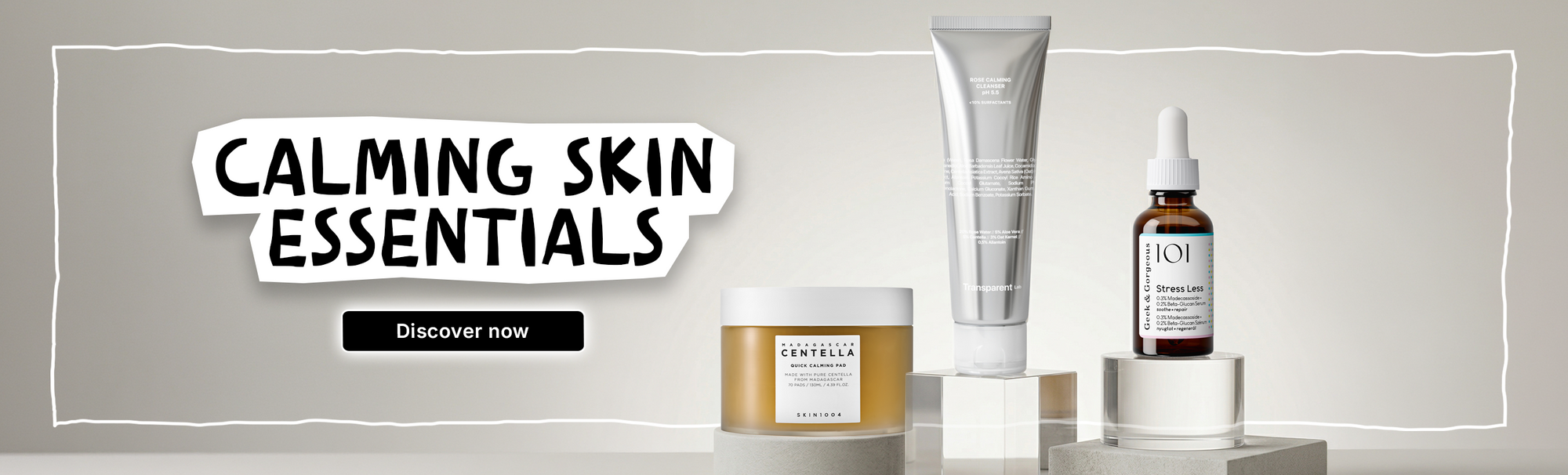 Drei Hautpflegeprodukte, die als "calming skin essentials" bezeichnet werden, sind auf klaren Ständern vor einem neutralen Hintergrund ausgestellt.