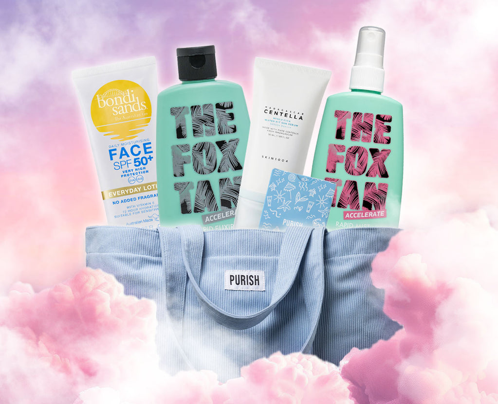 Eine hellblaue Purish-Tasche gefüllt mit Hautpflegeprodukten von Bondi Sands, The Fox Tan und SKIN1004, vor rosa Wolkenhintergrund.
