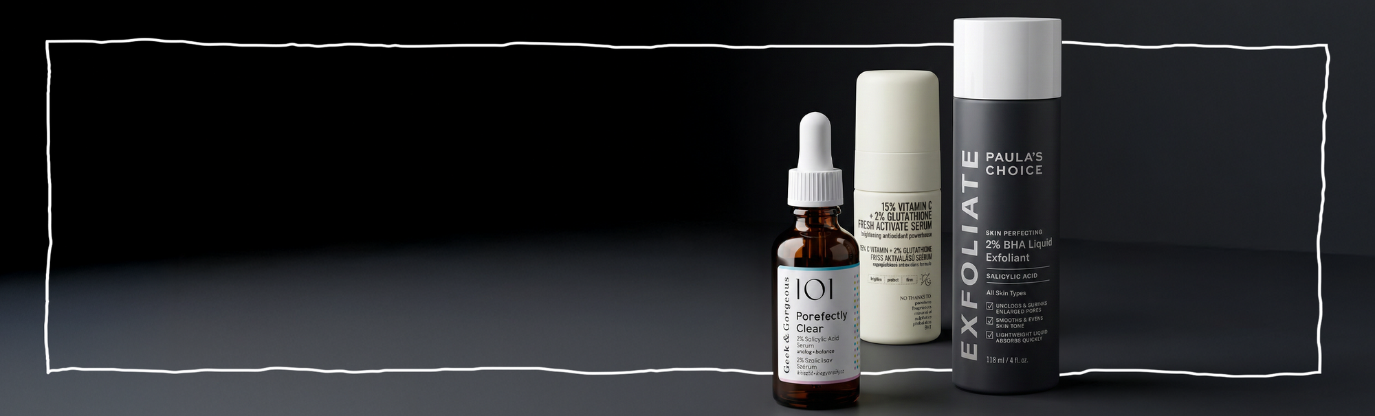 Exfoliating Skincare-Produkte: Paula’s Choice 2% BHA Liquid, Vitamin-C-Serum und klärendes Serum auf dunklem Hintergrund.