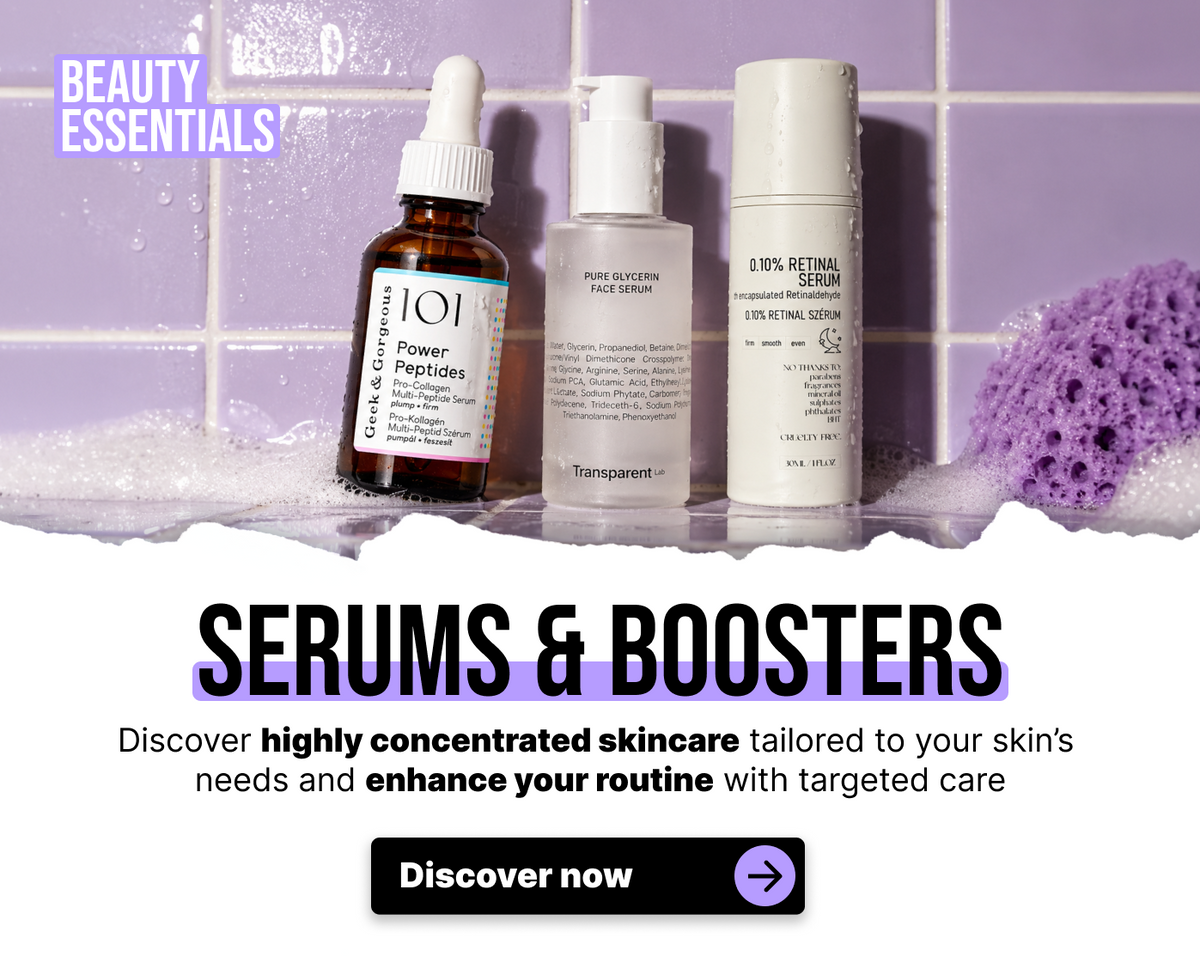 Drei Flaschen Gesichtsserum mit den Aufschriften Power Peptides, Pure Glycerin und 0,10 % Retinal Serum stehen auf einer mit violetten Fliesen ausgelegten Fläche, auf der sich Seifenschaum befindet.
