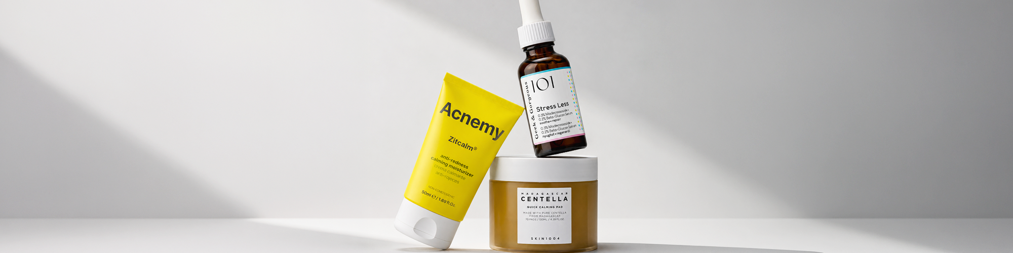 Drei Hautpflegeprodukte für dehydrierte Haut von Acnemy, Geek & Gorgeous und SKIN1004 auf hellem, minimalistischem Hintergrund.