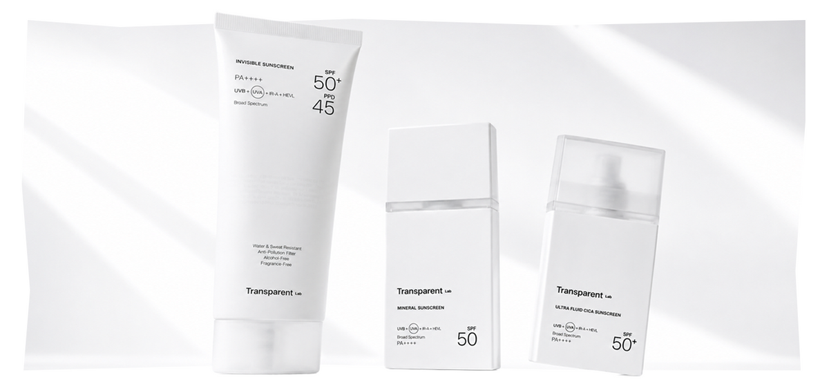 Drei weiße Sonnencremeflaschen mit der Aufschrift „Transparent Lab“ und den Lichtschutzfaktoren 50 und 45, vor einem weißen Hintergrund mit sanften Schatten.