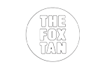 Logo mit der Aufschrift „THE FOX TAN“ in Großbuchstaben, zentriert in einem Kreis, vor transparentem, kariertem Hintergrund.